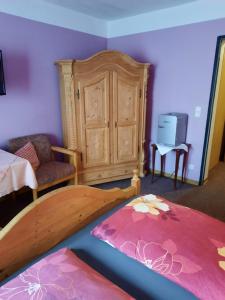 OrtenbergにあるLandgasthof Rotlipp Gästezimmerのベッドルーム(木製ベッド1台、ドレッサー付)