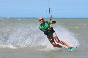 a man is water skiing in the ocean at Pousada Casa Caju Bangalows in Cumbuco