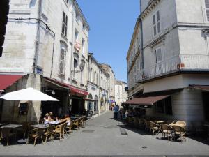 una calle vacía con mesas, sillas y edificios en L' Appart du Marché, en La Rochelle