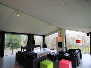 a living room filled with furniture and a piano at Villa Vink in Hollum