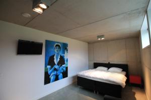 a bedroom with a bed and a painting on the wall at Villa Vink in Hollum
