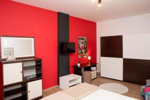 Apartman Isabella في داروفار: غرفة بجدار احمر بها سرير وتلفزيون