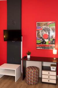Pokój z czerwoną ścianą ze stołem i biurkiem w obiekcie Apartman Isabella w mieście Daruvar