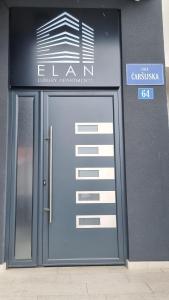 une porte menant à un bâtiment avec un panneau sur celui-ci dans l'établissement Elan Luxury Apartments & Rooms, à Plav