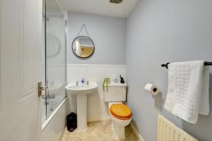 a bathroom with a sink and a toilet and a mirror at Modern 2 Bed House Sleeps 6 Southam Town Centre - Inspire Homes Ltd in Southam
