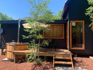 a house with a wooden deck and a hot tub at Cabañas Los Nevados in Nevados de Chillan
