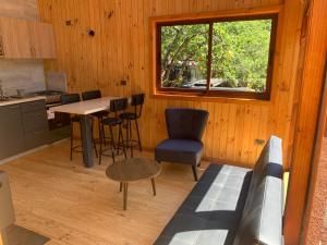 a kitchen with a table and chairs and a window at Cabañas Los Nevados in Nevados de Chillan
