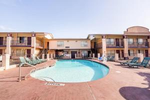 una piscina en un complejo con sillas y un edificio en OYO Hotel Texarkana North Heights AR Hwy I-30, en Texarkana