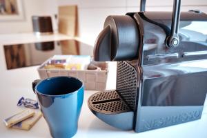 Eine Kaffeetasse sitzt neben einem Toaster. in der Unterkunft Schicke & helle Wohnung in Mülheim an der Ruhr in Mülheim an der Ruhr