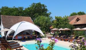 - une piscine avec des chaises et un parasol blanc dans l'établissement Remser Haus, à Zalakaros