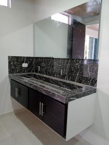 W łazience znajduje się umywalka i lustro. w obiekcie Villas Campestres las Heliconias - Villa Ginger w mieście Villavicencio