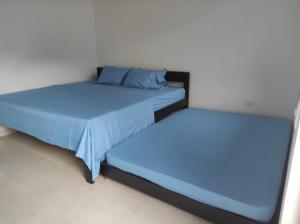 dos camas sentadas una al lado de la otra en una habitación en Villas Campestres las Heliconias - Villa Ginger, en Villavicencio