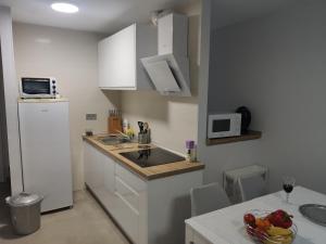 una pequeña cocina con fregadero y microondas en Maríahome, en Almería