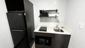 una pequeña cocina con fregadero y nevera. en Studio 6 Lafayette, LA I-10 & I-49 N, en Lafayette