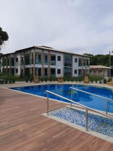 a swimming pool in front of a building at Ilhéus North Residence in Uruçuca