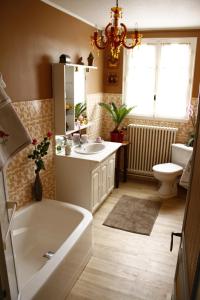 a bathroom with a tub and a sink and a toilet at La Petite Maison près de l'Eglise in Meillac +20 photos
