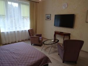 カリーニングラードにあるApartment on Dmitriya Donskogo 20のベッドルーム(ベッド1台、テレビ、椅子付)