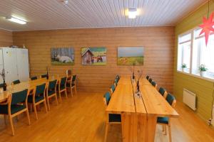 una sala de conferencias con mesas y sillas de madera largas en Fosseland Gjestegård, en Feda