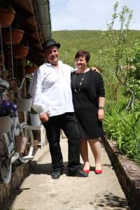 a man and a woman standing next to a building at Apartment Ada bed & breakfast in Gračac