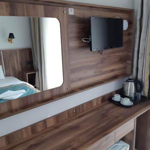 a mirror in a bedroom with a bed and a tv at Elijah Hotel in Kemer