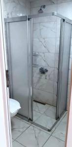 een douche met een glazen deur in de badkamer bij Elijah Hotel in Kemer