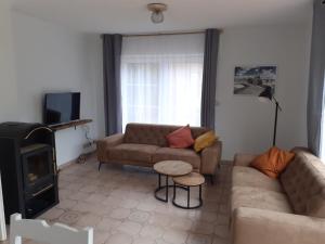 ein Wohnzimmer mit einem Sofa und einem TV in der Unterkunft Küstenhaus Duhnen - Erdgeschoss mit Terrasse in Cuxhaven