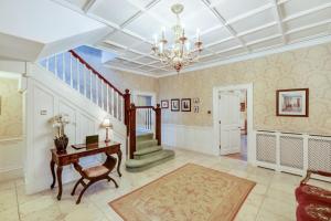 a living room with a staircase and a desk and a chandelier at Blackpool Abode - Southlands in Blackpool