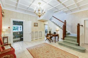 a living room with a staircase and a chandelier at Blackpool Abode - Southlands in Blackpool