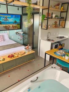 Cette chambre comprend un lit et une baignoire. dans l'établissement Loft's do Sonho LOFT 01, à Palhoça
