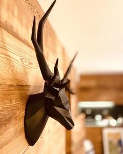 a black bow tie hanging on a wooden wall at Wooden House “Campo Smith” in Bardonecchia