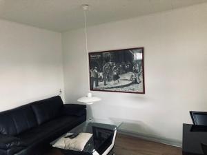 sala de estar con sofá y una foto en la pared en Vejlegades skomager, en Nakskov