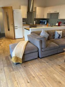 a living room with a couch and a kitchen at Fantastic Cottage in Loch Lomond National Park in Alexandria