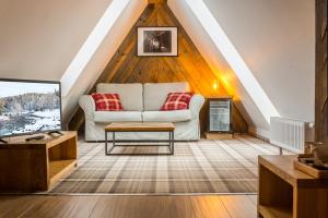 a living room with a couch and a tv at Gościniec Kuźnice in Zakopane