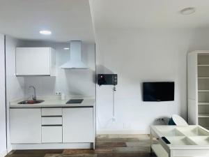 Una cocina con gabinetes blancos y un fregadero. en Lovely Triana flat with roof terrace, en Sevilla