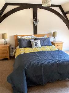 a bedroom with a large bed with a blue comforter at Fantastic Cottage in Loch Lomond National Park in Alexandria