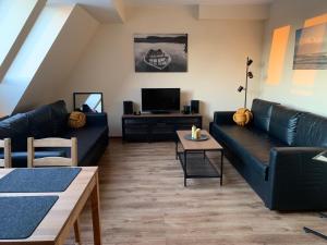 ein Wohnzimmer mit 2 Sofas und einem TV in der Unterkunft Apartament Żeglarski Vęgoria Deluxe z widokiem na Port in Angerburg