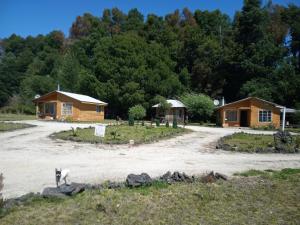 a cabin and a house with a dirt road at Cabañas el Estero in Melipeuco