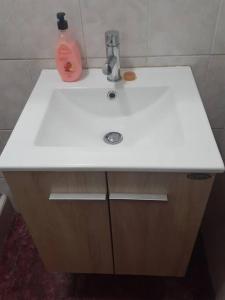 ein weißes Waschbecken mit einem Seifenspender darauf in der Unterkunft Hospedaje San Isidro in Lima