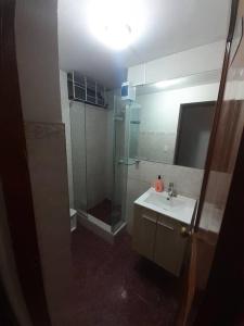 ein Bad mit einer Glasdusche und einem Waschbecken in der Unterkunft Hospedaje San Isidro in Lima