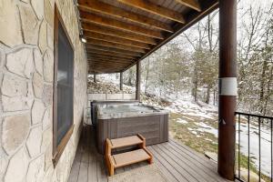 a wooden deck with a hot tub and a bench at Inspiration Point in Dupont Springs