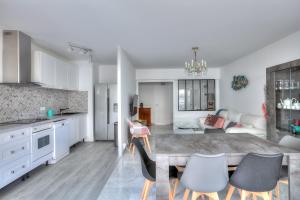 cocina y sala de estar con mesa y sillas en Le Sun-Beach - Spacieux 3 pièces avec parking à 400 m des plages de Juan-les-Pins, en Juan-les-Pins