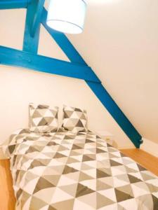 um quarto com uma cama com um tecto azul em Le petit nid du Mont Saint Michel em Pontorson