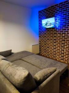 - une chambre avec un lit et un mur en briques avec une télévision dans l'établissement Le petit nid du Mont Saint Michel, à Pontorson 3 autres photos