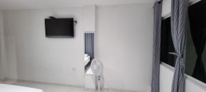 a white room with a fan and a tv on a wall at Apartaestudio acogedor cerca al Estadio Metropolitano in Barranquilla