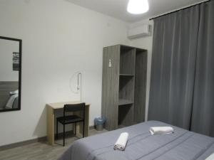 1 dormitorio con cama, escritorio y silla en B&B Maison la Metro, en Somma Vesuviana