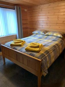 a bedroom with a bed with yellow towels on it at Corrie Lodge, Glendevon in Glendevon