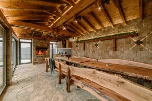 a large room with wooden benches and a fireplace at Вила Рустик / Villa Rustic in Kyustendil