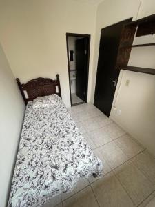 een slaapkamer met een bed met een deken erop bij Cantinho em Ouro Preto in Ouro Preto