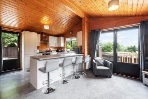 a kitchen with a bar with stools in a room at Corrie Lodge, Glendevon in Glendevon
