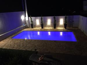 a blue swimming pool at night with lights at tranquilidade in Serra Negra